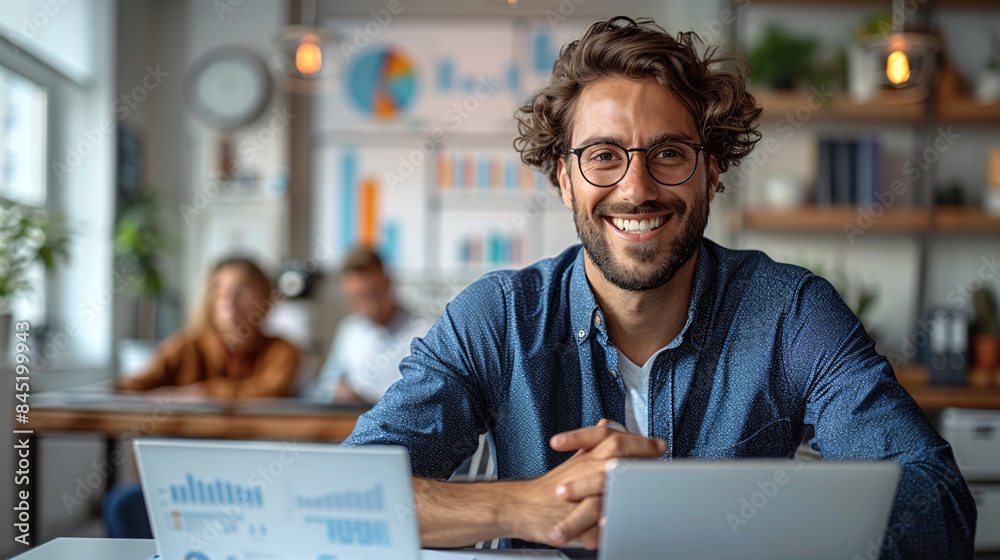 Wall mural A financial planning session with a group of young professionals discussing investment options with a planner in a white conference room, with laptops and charts on the table. The image features