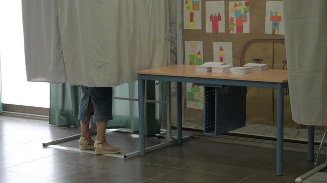 Legs of a voter inside a voting booth, selecting their vote