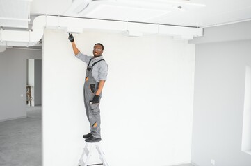 Fototapeta premium African HVAC Technician Worker Testing Newly Installed Ventilation System. Commercial Heating, Cooling and Air Ventilation Systems