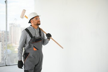 Indian Painter painting the office wall with roller paint