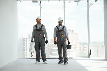 multicultural builders in hardhats at construction site