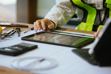 Person's engineer Hand Drawing Plan On Blue Print with architect equipment, Architects discussing at the table, team work and work flow construction concept.