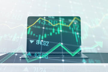 Close up of office desk top with laptop and growing green forex chart and arrows on blurry background. Index, finance and market growth concept. Double exposure.