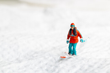 A miniature figurine of a skier dressed in vibrant winter gear. This image is perfect for themes...