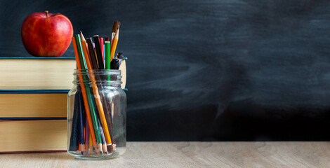 The concept of education, stack of books, an apple, pencils against the background of the school...