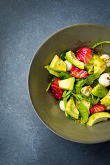 Salad with salmon, avocado, spinach and mozzarella cheese. Close up.