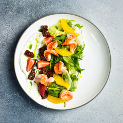 A colorful salad of shrimp, arugula and sun-dried tomatoes. Italian cuisine. Top view.