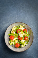 Mashed potatoes with spinach sauce and cherry tomatoes, arugula. In a plate.
