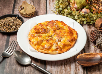 hawaiian pizza with spoon and fork served in plate isolated on wooden table side view of taiwan fasfood