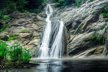 Obraz premium Smooth and long waterfall between rocks shot in high exposure and nobody around
