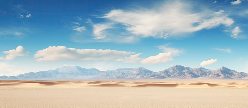 A stunning landscape of the Nevada desert with a wide expanse of golden sand and clear blue skies The photo provides ample space for copy or other content