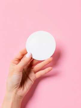 female hand holds a round sticker on a pink background. mockup stickers
