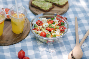 Fresh vegan salad outdoors on blue checkered napkin. Vegan food concept outdoor