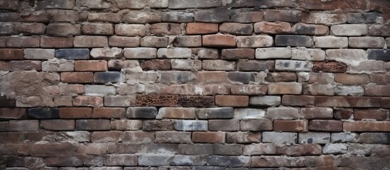 Fototapeta premium An aged brick wall creates a captivating backdrop with its delicate blend of gray and brown hues The image offers ample copy space for various purposes