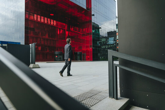 Businessman walking at street by modern buildings
