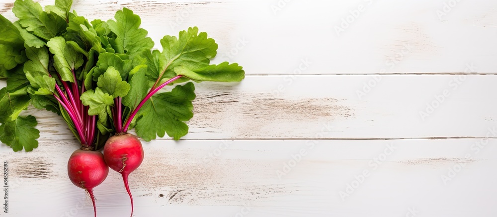 Poster a single vibrant red radish with its fresh green leaves set against a white wooden background a vege