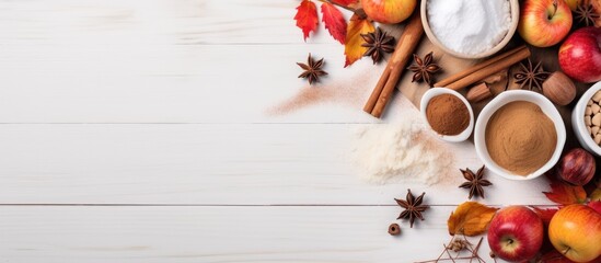 A fall themed baking sale with a copy space image of seasonal ingredients spices apples and supplies arranged on a white wooden table top view