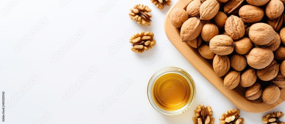 Aufkleber a top down view of a jar of walnut oil placed near a bowl of walnuts on a white background offering 