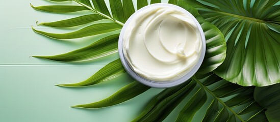 A green scrub with gel like texture is seen on a white background along with green palm leaves The image also features a skin cleansing cream and enough space for additional content