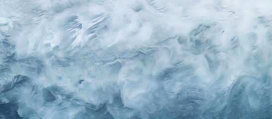 Obraz premium The snowy ice sea surface on a cold winter day creates an abstract natural background The frozen snow waves texture looks beautiful The top view offers a flat lay with empty space for text It s a cop
