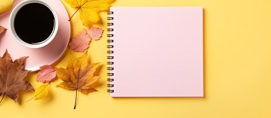 Top down view of a Christmas themed workspace with a spiral notepad pink pen and a yellow background providing ample copy space for a cozy and organized letter writing experience