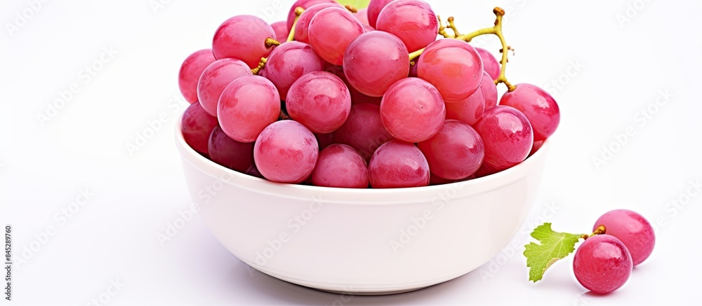 Poster the image shows a top view of a bowl filled with pink grapes kishmish the grapes are isolated on a w