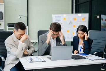 Furious two Asian businesspeople arguing strongly after making a mistake at work in panic after...