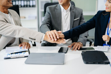 Teamwork business concept of group of three coworkers join hand together during their meeting.