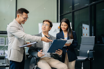 Happy Asian businesspeople while collaborating on a new project.  using a laptop and tablet