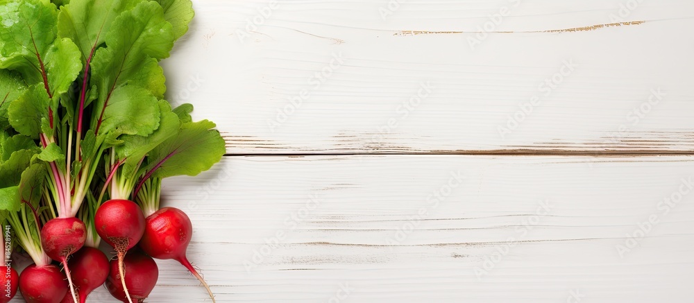 Poster a single vibrant red radish with its fresh green leaves set against a white wooden background a vege