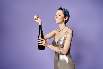 Young woman with short blue hair posing elegantly in a silver dress, holding a bottle of champagne.