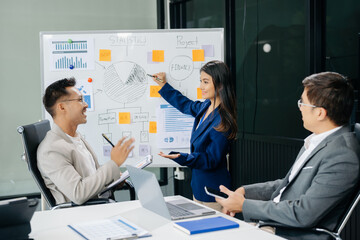 Office colleagues have a casual discussion. During a meeting in a conference room, a group of Asian business teem sit in the conference room