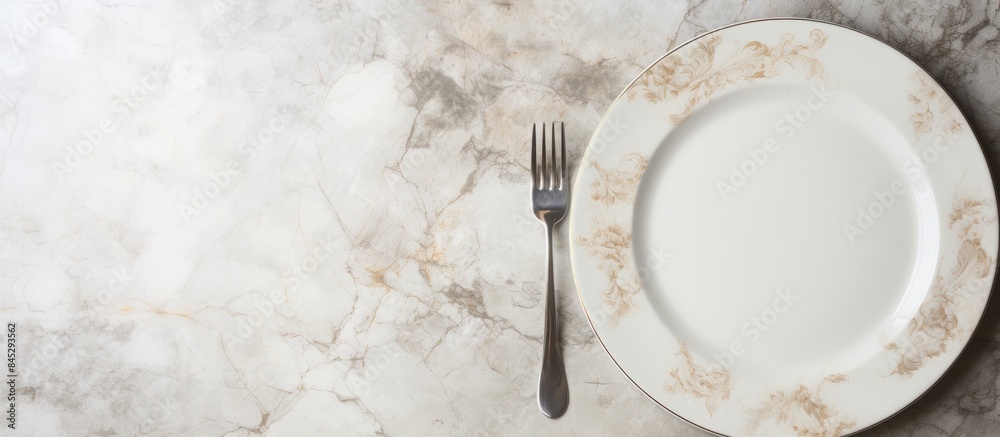 Poster a white dinner plate sits on a white marble surface featuring intricate patterns a shiny silver spoo