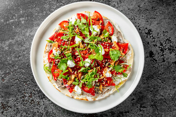 Vibrant image of a gourmet roti with assorted toppings, served on a white plate against a dark background. Perfect for Italian cuisine concepts