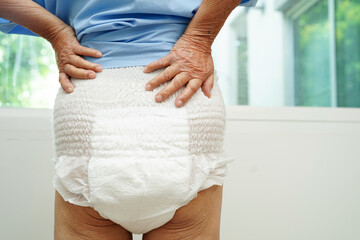 Asian senior woman patient wearing adult incontinence diaper pad in hospital.