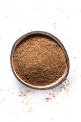 Coconut palm sugar in coconut bowl isolated on white background. Top view