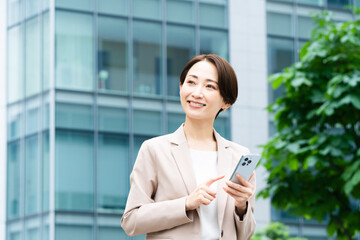 スマートフォンを操作している若い女性　ビジネスイメージ