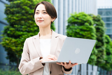 Fototapeta premium ノートパソコンを操作している若い女性 ビジネスイメージ