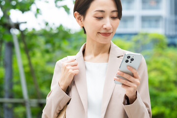 スマートフォンを操作している若い女性　ビジネスイメージ