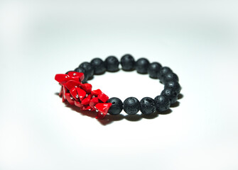 Bransoletka z lawy wulkanicznej i czerwonych kamieni naturalnych na białym tle