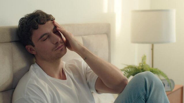 Tired European Caucasian man bed rubbing eyes insomnia unhealthy bedroom male guy weary exhausted sick overwork credit loan pressure sad unhappy worried illness frustration sleepy asleep upset problem