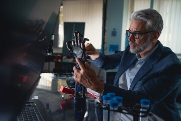 Robotics engineer adjusting, calibring robotic prosthetic hand. Concept of modern technology in medicine. Robotic prosthetics, biomechatronics and neuroscience.