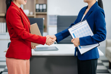 Business people shaking hands during a meeting. Two happy mature businesswomen