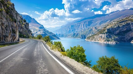 Empty highway between mountain peaks, lake in the gorge, clear sunny day, incredible nature, bright saturated colors