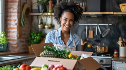 A woman standing at a table in her kitchen and unpacking a box of delivered fresh groceries