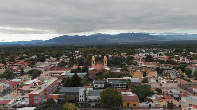 Aerial drone shot of residential houses in cafayate town of Argentina with Andean Cordillera Mountain Range in Background
