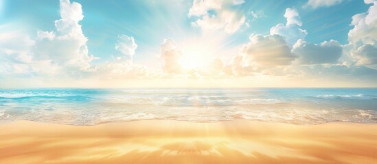 Fototapeta premium Blurred background of a tropical summer beach with sun rays, golden sand, blue sea, and white clouds; perfect for a summer vacation theme.