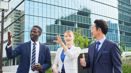 街で外国人ビジネスパーソンを案内する日本人ビジネスマン