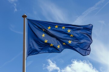 European common market flag in a pole. Blue sky. Clouds. Sunny day. Waving.