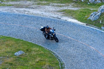 Obraz premium Scenic view of mountain pass road named Tremola with motorcyclist way up at Swiss mountain pass Gotthard on a sunny late summer day. Photo taken September 10th, 2023, Gotthard, Switzerland.